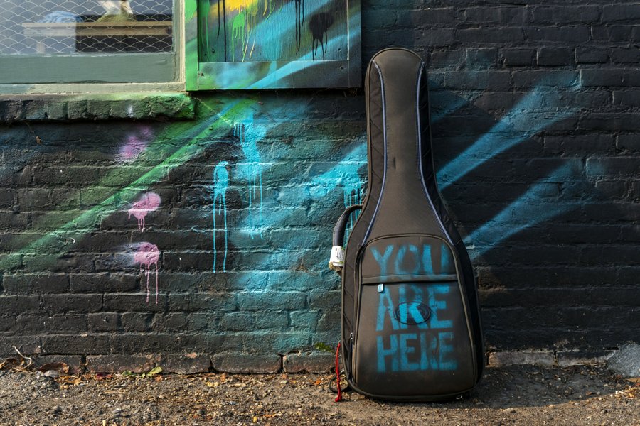 Guitar case against a painted brick wall
